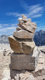 Stack of stones on rock against sky