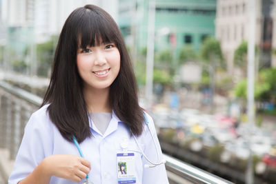 Portrait of doctor standing by railing