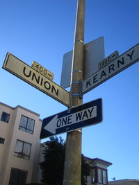 Low angle view of sign board against blue sky