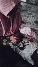 High angle view of woman sitting on bed at home