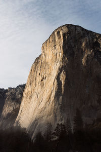 Low angle view of rocky mountain against sky