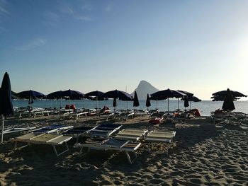 Scenic view of beach umbrellas against clear sky