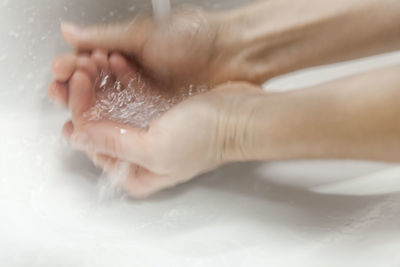 Close-up of hands in bathroom