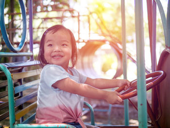 Portrait of smiling girl sitting outdoors