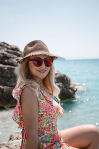 Portrait of woman wearing sunglasses against sky