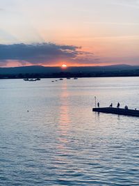 Silhouette boat in sea against sky during sunset