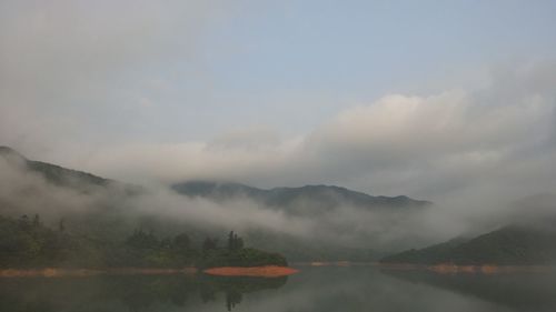 Scenic view of lake against cloudy sky