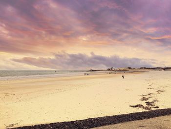 Scenic view of beach against cloudy sky