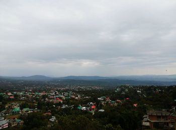 View of cityscape against cloudy sky