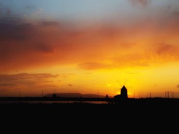 Silhouette buildings against sky during sunset