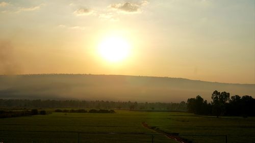 Scenic view of field against sky during sunset