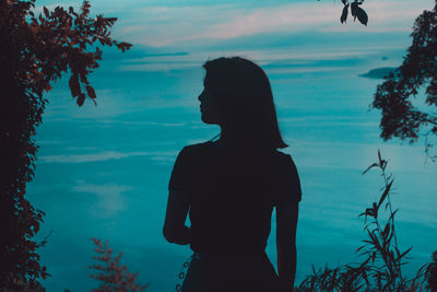 Silhouette woman looking at sea against sky