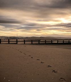 Bridge over sea against sky during sunset