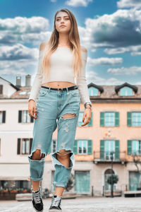 Full length of young woman standing in city