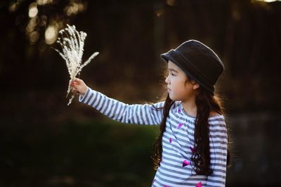 Girl holding plant in park