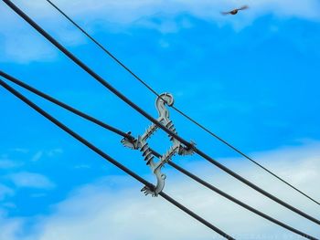 Low angle view of power lines against blue sky