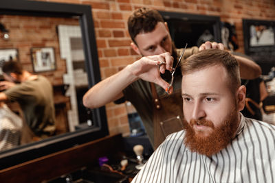 Barber cutting man's hair at salon