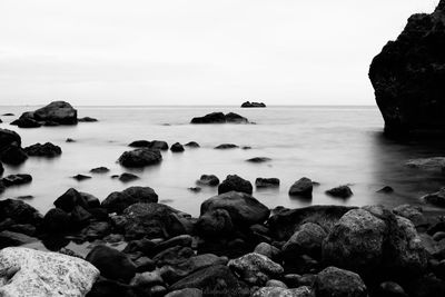 Rocks on sea shore against sky