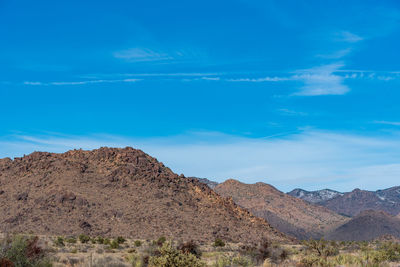 Scenic view of mountains against blue sky