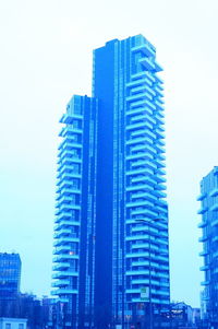 Low angle view of skyscrapers against clear blue sky