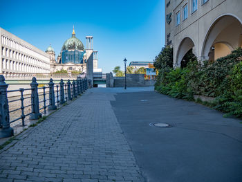 Footpath amidst buildings in city