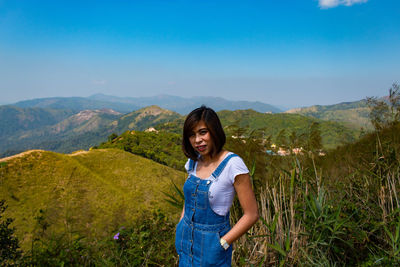 Portrait of woman standing on mountain against sky