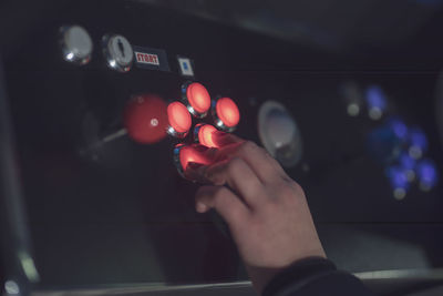 Cropped hand touching illuminated buttons