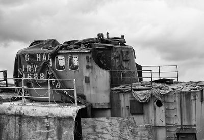 Low angle view of old abandoned ship against cloudy sky