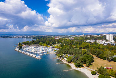 High angle view of city by sea against sky