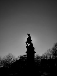 Low angle view of silhouette statue against sky