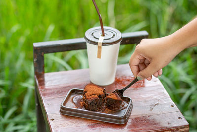 Midsection of person holding coffee cup on table