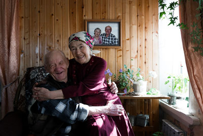 Happy old couple hugging at home