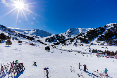 People skiing on snowcapped mountain against sky
