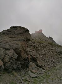 Low angle view of rocks on mountain against sky