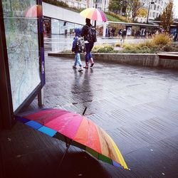 People with umbrella on wet floor during rainy season