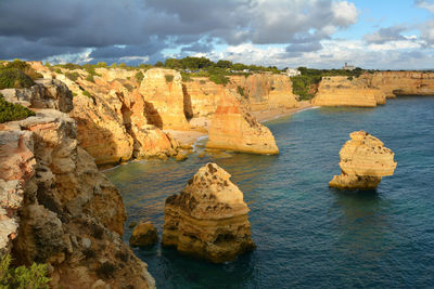 Rock formations by sea against sky