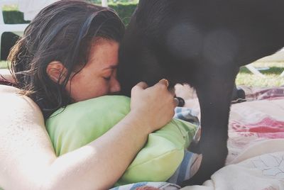 Midsection of woman with dog relaxing on bed at home