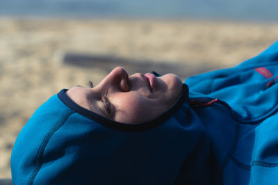 Side view of a smiling woman on the beach in outdoor clothes