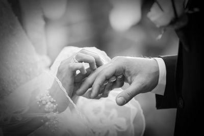 Midsection of bride and groom holding hands during wedding ceremony