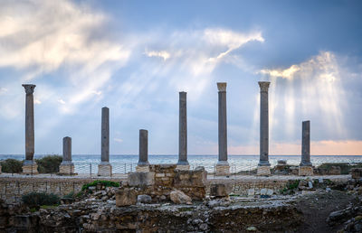 Panoramic view of factory by sea against sky