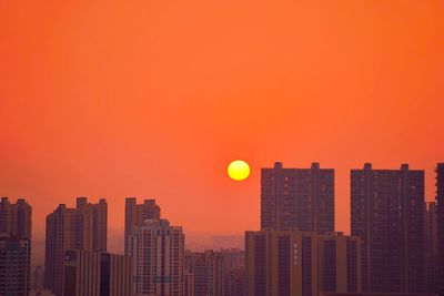 Modern cityscape against orange sky