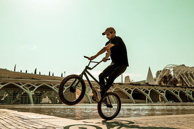 Man riding bicycle on bridge