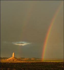 Scenic view of rainbow over landscape against sky