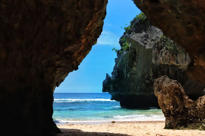 Scenic view of rock formation by sea against sky