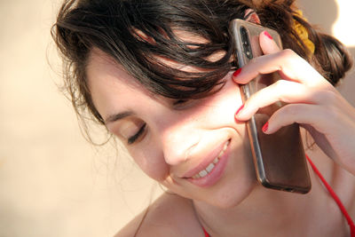 Close-up portrait of a smiling young woman holding camera