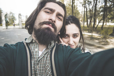 Portrait of young couple standing at park