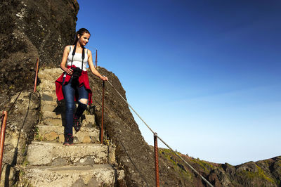 Low angle view of young woman standing on steps