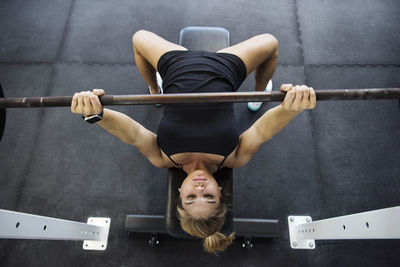 High angle view of confident athlete exercising with barbell in crossfit gym