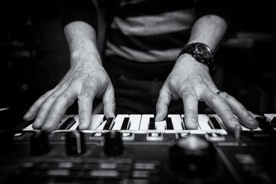 Midsection of man playing piano