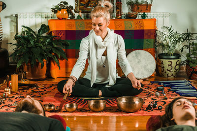 Therapist playing rin gong by couple while performing music therapy at spa